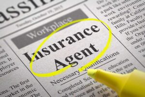 A couple reviews life insurance documents at a kitchen table beside a calculator and household budget.